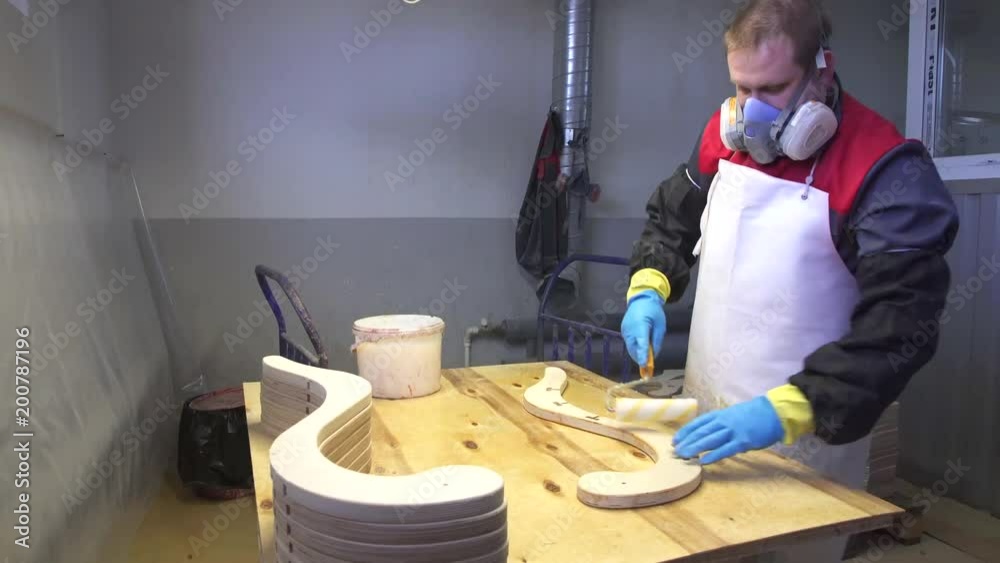 Industrial carpenter worker varnishing on wood dolly shot Industrial carpenter worker varnishing on wood dolly shot