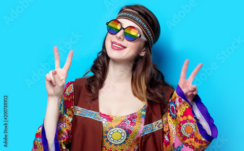 Portrait of Young hippie girl with rainbow glasses on blue background