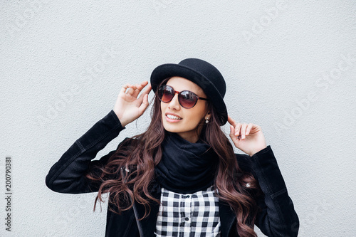 Smiling urban girl with smile on her face. Portrait of fashionable gir wearing a rock black style having fun outdoors