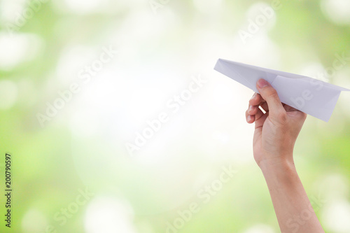 close up hand hold paper rocket ob blur green nature background for creative idea concept