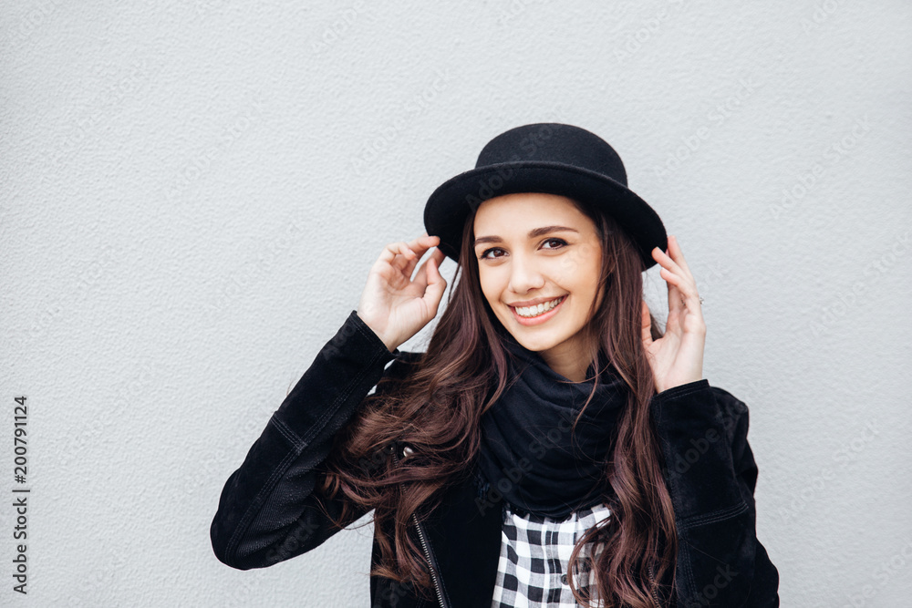 Smiling urban girl with smile on her face. Portrait of fashionable gir wearing a rock black style having fun outdoors Smiling urban girl with smile on her face. Portrait of fashionable gir wearing a rock black style having fun outdoors