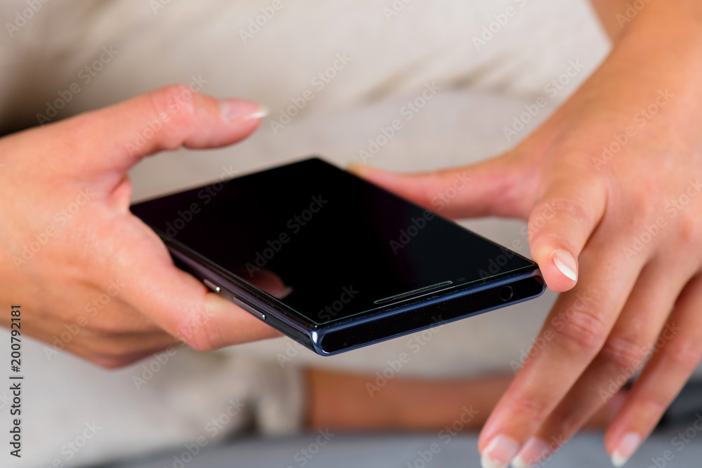 Woman sitting on bed and writing message on cellphone. Woman sitting on bed and writing message on cellphone.