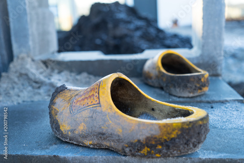 Traditional Dutch wooden shoes clogs used at a construction site with clay and dirt on them