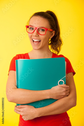 Geek student with glasses in red t shirt over yellow background