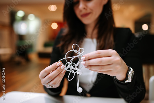 Konstfotografi Close up image of stylish woman holding tangled headphones.