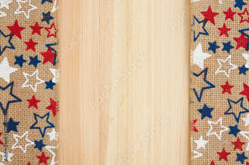 Red, white and blue stars burlap ribbon on wood background