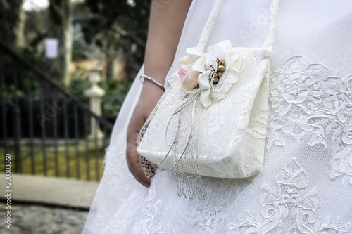 Nina vestida con accesorios y bolso de primera Comunion Photos Adobe Stock