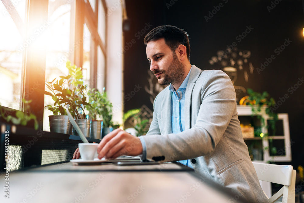 Entrepreneur drinking a cup of coffee while working at the cafe Entrepreneur drinking a cup of coffee while working at the cafe