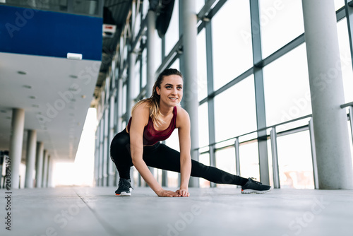 Young sporty woman warming up before run, indoors.