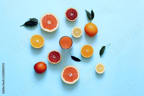 Fresh juices and fruit cut into slices on a turquoise background