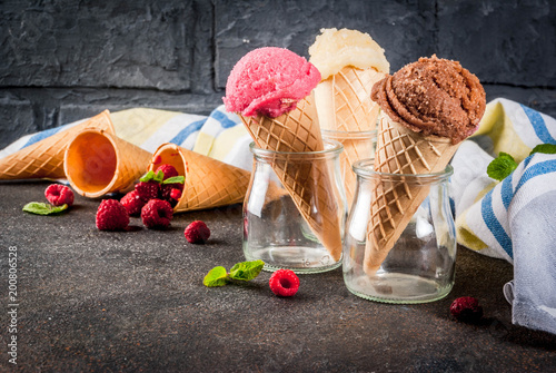 Summer sweet berries and desserts, various of ice cream flavor in cones pink (raspberry), vanilla and chocolate with mint on dark background copy space