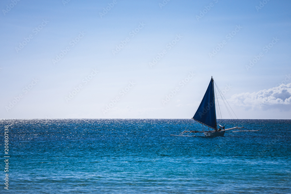 One double outrigger sailboat on the sea