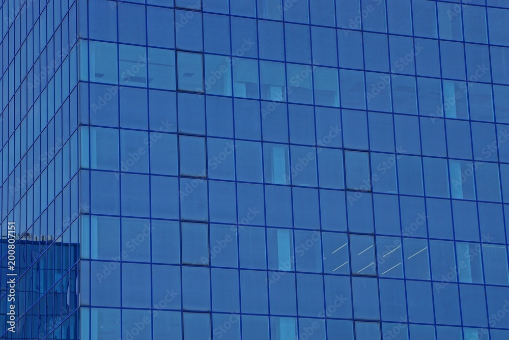 blue glass texture of windows on the wall of a tall building blue glass texture of windows on the wall of a tall building