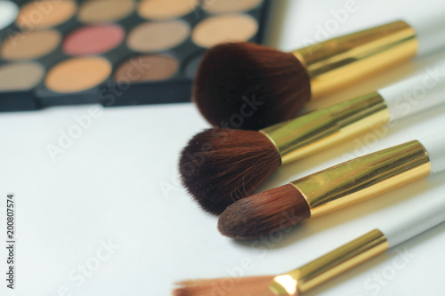 makeup brushes, eyeshadow and powder isolated on white background