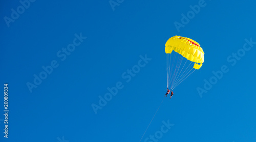 yellow parachute flight. A parachute with a smile. Rest on the water. Journey through the sky. Active time at the resort. Beach entertainment.
