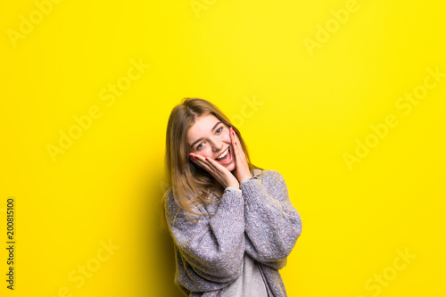 Excited of joy. Teen girl feeling ecstatic of surprise shouting isolated on yellow background