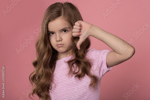 beautiful caucasian girl with bright red hair posing on a pink background. Curly hair of red color