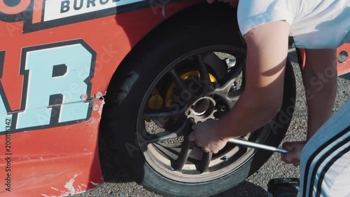 Mechanics change the wheel on a racing car photo