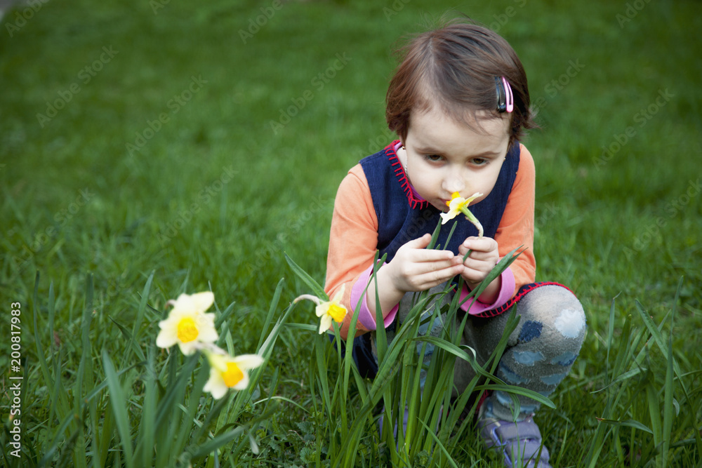 Little girl enjoys the smell of flowers on the yellow field (Recreation, summer, nature, vacation concept) Little girl enjoys the smell of flowers on the yellow field (Recreation, summer, nature, vacation concept)