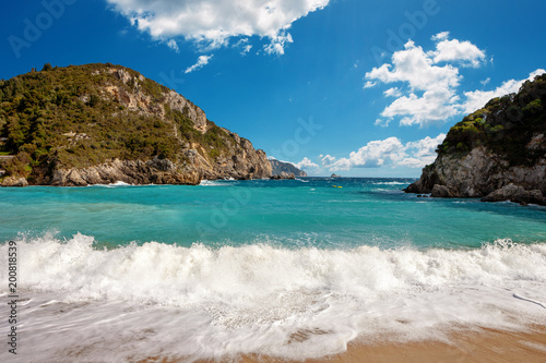 Beautiful beach with big waves and a nice cloudscape at Paleokastritsa in Corfu, Greece