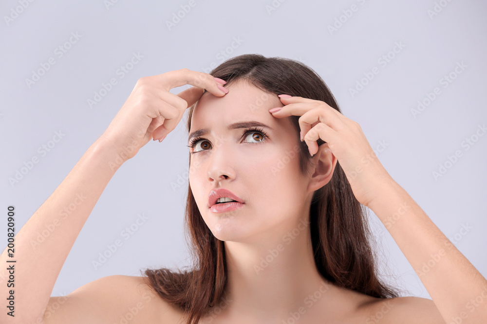 Naklejka premium Teenage girl with acne problem against grey background