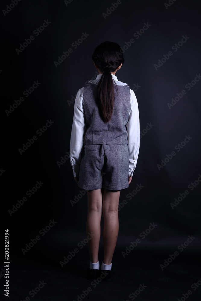 Business Kid Girl in formal suit stand on dark abstract background Business Kid Girl in formal suit stand on dark abstract background