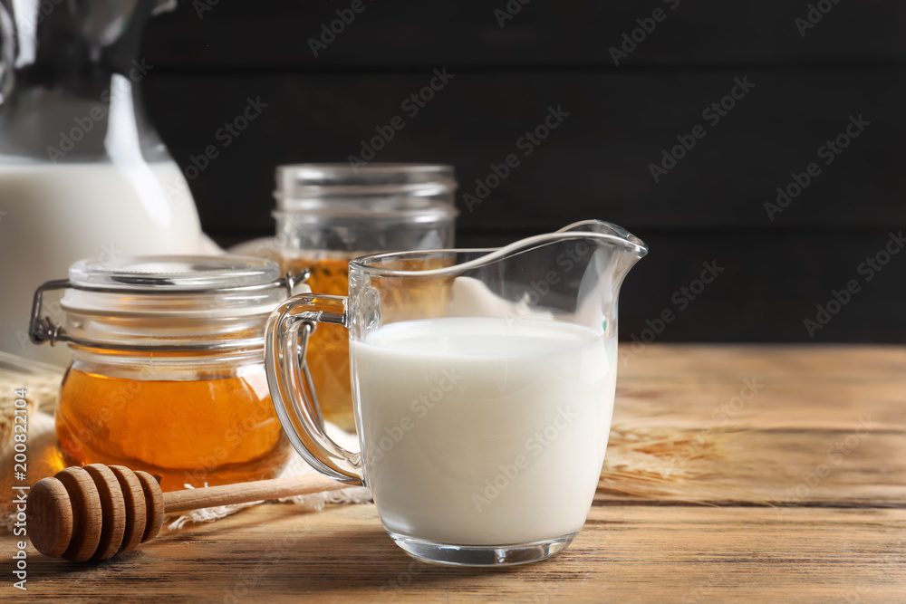 Beautiful composition with milk and honey on wooden table