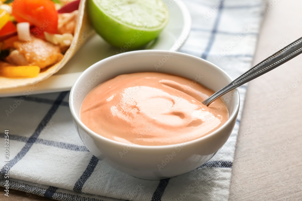 Tasty creamy sauce for fish taco in bowl on wooden table Tasty creamy sauce for fish taco in bowl on wooden table
