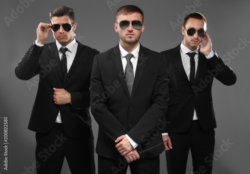 Handsome bodyguards on grey background