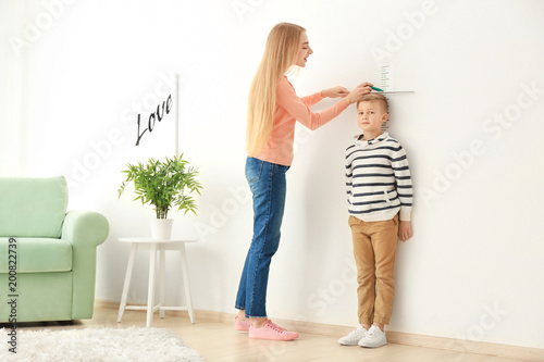 Young woman measuring heigh...