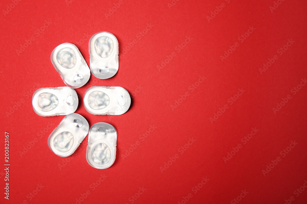 Flat lay composition with contact lenses in packages on color background Flat lay composition with contact lenses in packages on color background