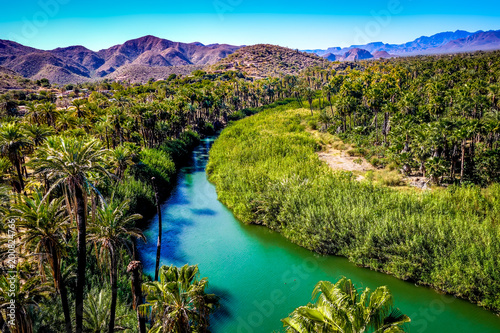 The blue-green Mulege river curves through a desert oasis in Baja California Sur, Mexico