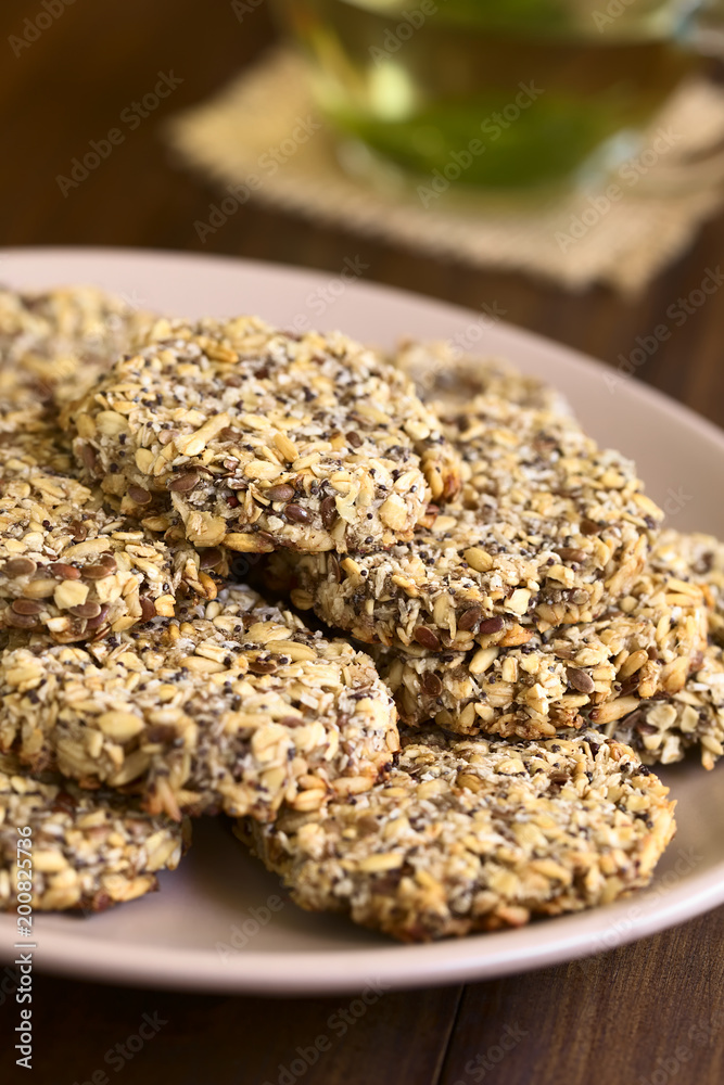 Vegan cookies made of banana, oatmeal and roasted oat grain, linseed, poppy seed, grated coconut, chia, cinnamon, photographed with natural light (Selective Focus on the front of top cookie) Vegan cookies made of banana, oatmeal and roasted oat grain, linseed, poppy seed, grated coconut, chia, cinnamon, photographed with natural light (Selective Focus on the front of top cookie)