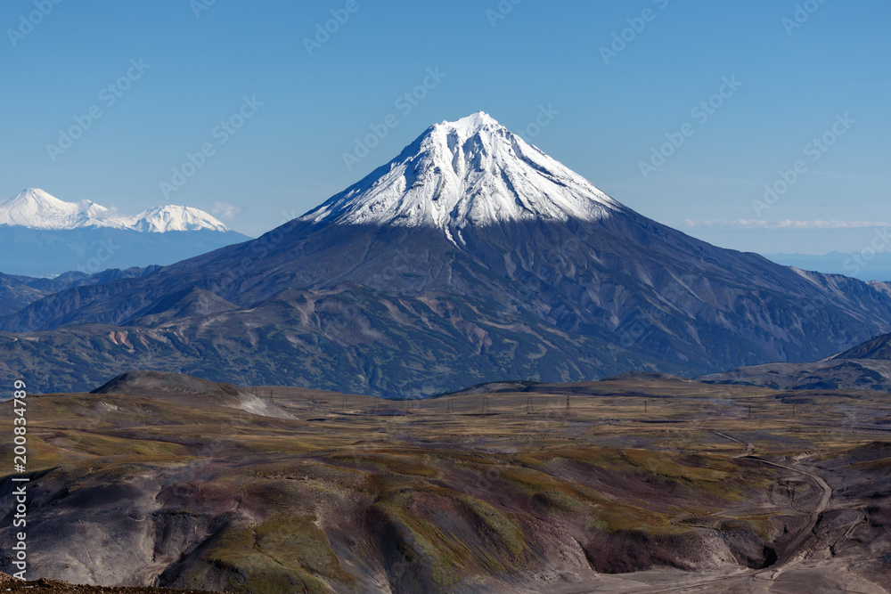 Scenery autumn mountain landscape - view of snowcapped cone of volcano