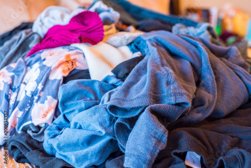 unfolded clothes on bed 