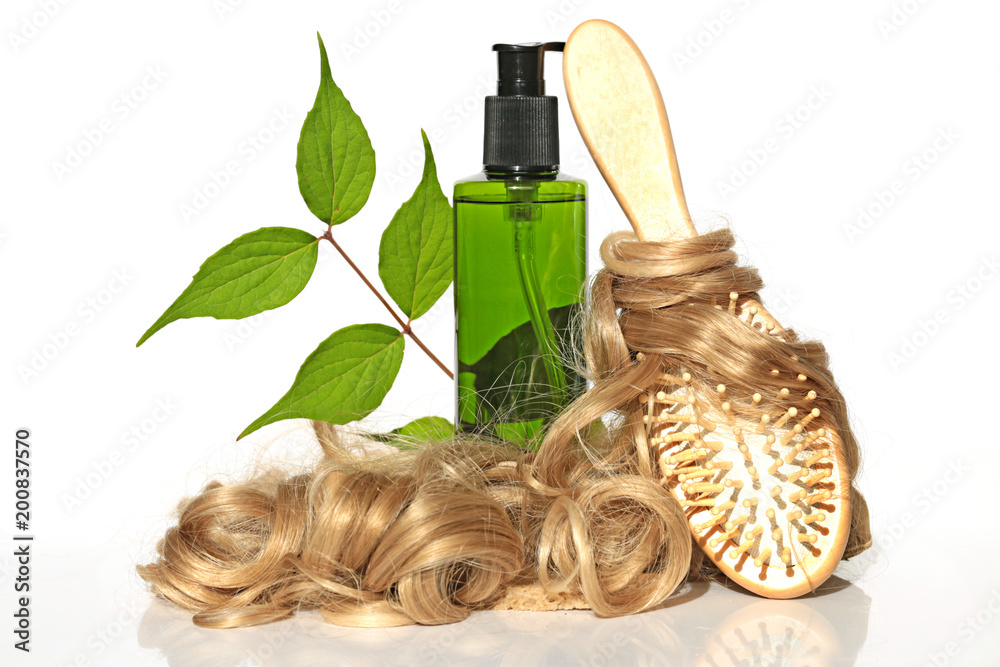 Fototapeta premium Natural Herbal Cosmetics for Hair. cosmetic with herbal extract, light curls and comb on white background. Bio green organic hair cosmetics