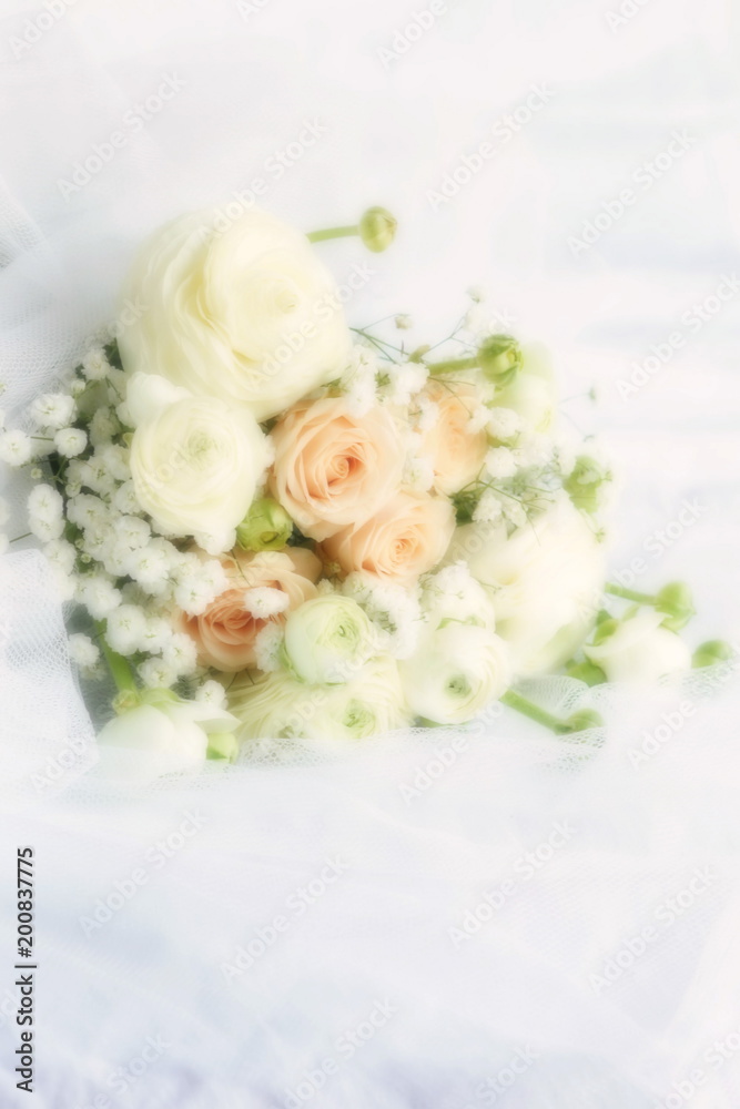 Blure effect, soft focus. Beautiful bridal bouquet from pale pink roses and white ranunculus flowers on white linen fabric background. copy space Blure effect, soft focus. Beautiful bridal bouquet from pale pink roses and white ranunculus flowers on white linen fabric background. copy space