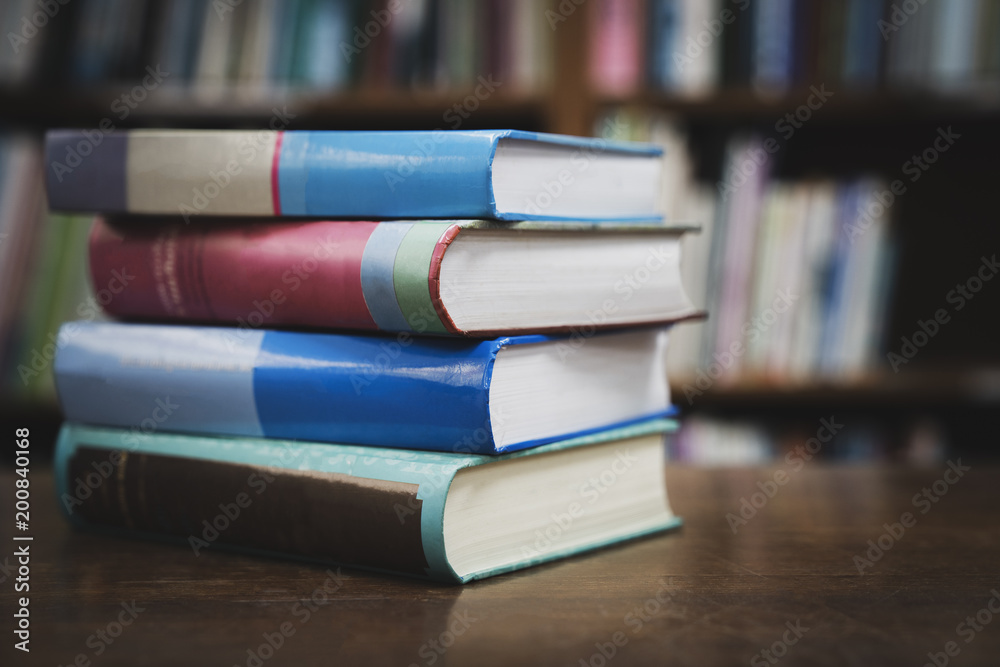 Book stack in the library room and blurred bookshelf for business and education background, Back to school concept Book stack in the library room and blurred bookshelf for business and education background, Back to school concept