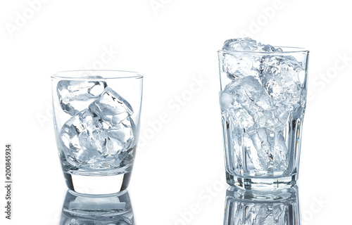 Empty glass with ice cubes on white background