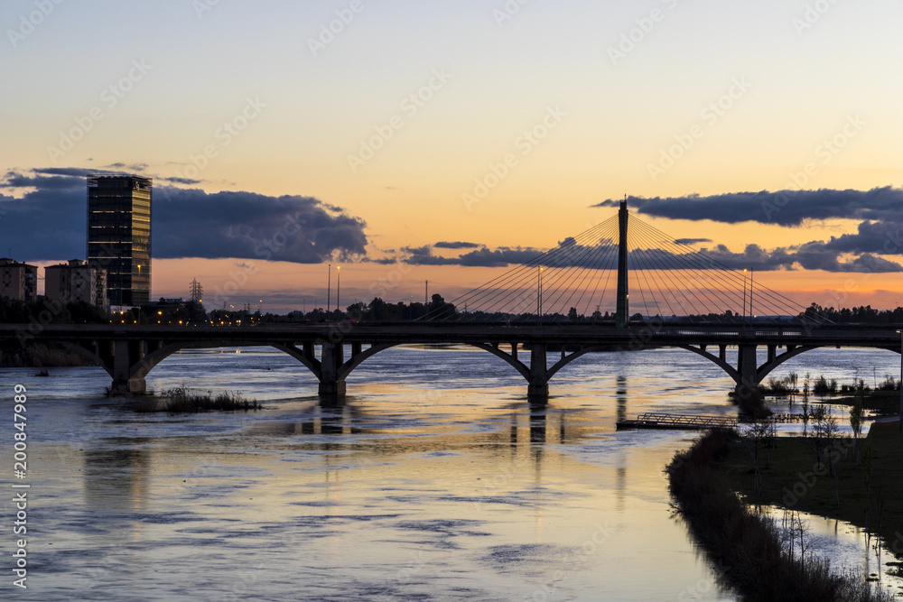 Badajoz, Spain. Views at sunset of river Guadiana, the Torre Caja Badajoz tower, and the Puente Real (Royal Bridge), from the Puente de Palmas bridge
