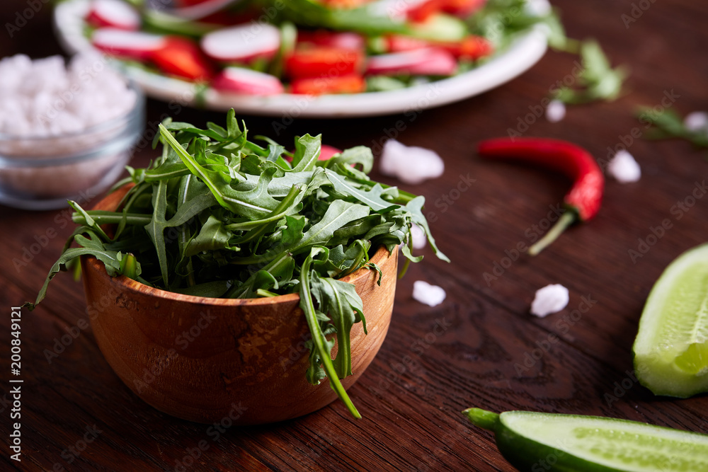 Creative fresh vegetable salad with ruccola, cucumber, tomatoes and raddish on white plate, selective focus Creative fresh vegetable salad with ruccola, cucumber, tomatoes and raddish on white plate, selective focus
