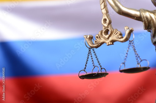 Scales of Justice, Justitia, Lady Justice in front of the Russian flag in the background.