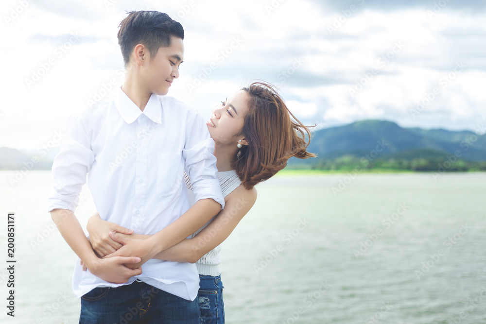 women couple in white cloth are standing and hug together between travel at giant lake. women couple in white cloth are standing and hug together between travel at giant lake.