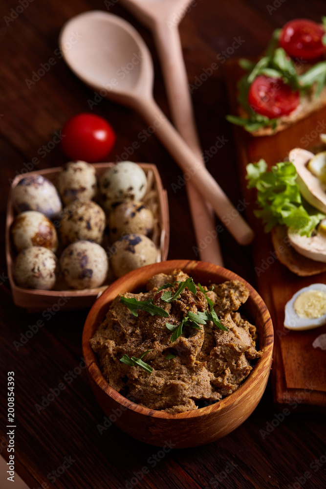 Paste from chicken liver with vegetables and quail eggs, shallow depth of field, close-up.