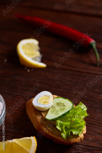 Breakfast sandwich with homemade paste, vegetables and fresh greens, shallow depth of field photo