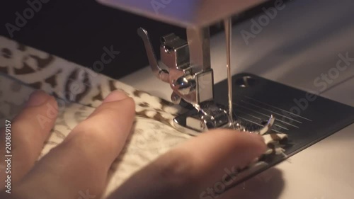 Woman hands working with domestic sewing machine.