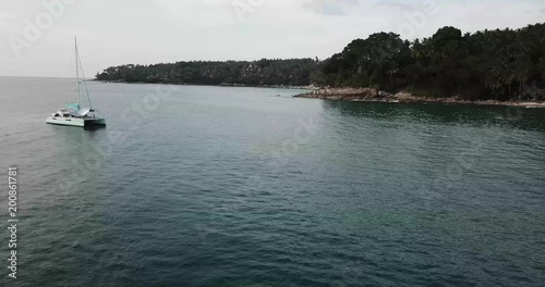 Flying over the yacht and the man on the surfboad

