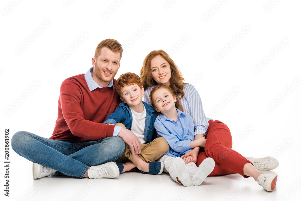 happy redhead family with two kids sitting together and smiling at camera isolated on white happy redhead family with two kids sitting together and smiling at camera isolated on white
