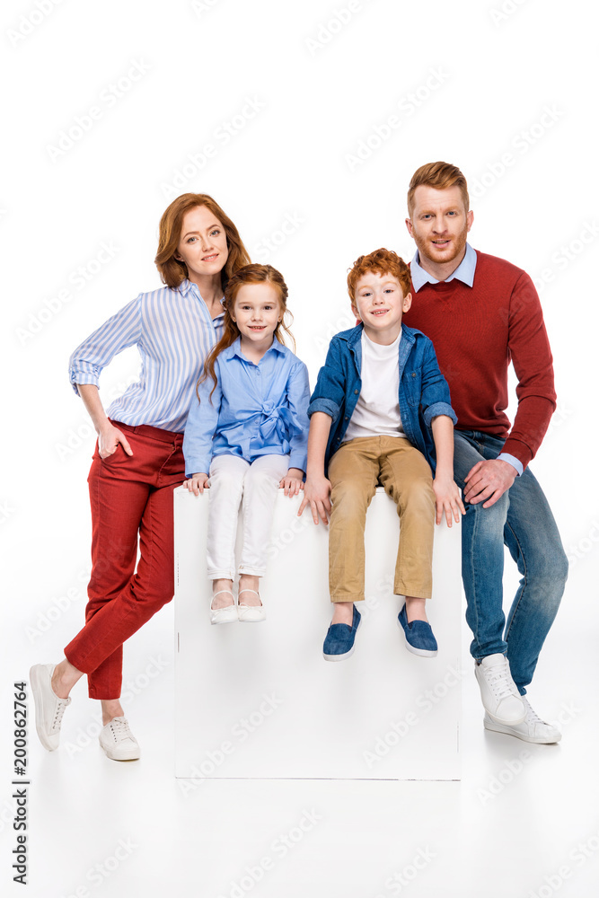 happy redhead family with two children smiling at camera isolated on white