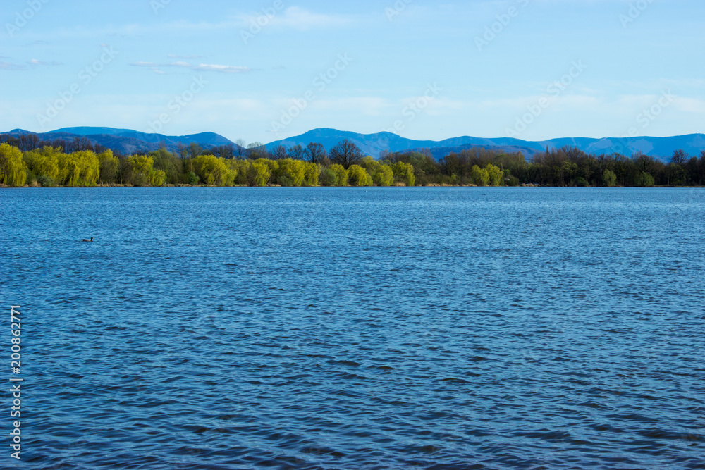 Blue water in lake - background mountains Beskydy
